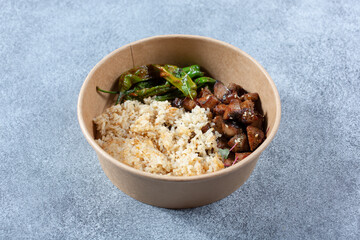 A view of a paper container featuring Asian BBQ beef and fried rice.