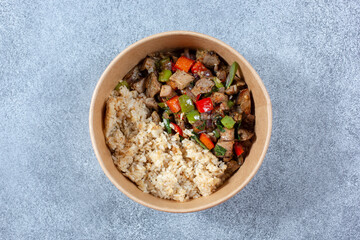 A top down view of a pepper beef entree in a paper container.