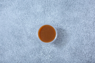 Obraz na płótnie Canvas A top down view of a plastic condiment cup of balsamic vinaigrette dressing.