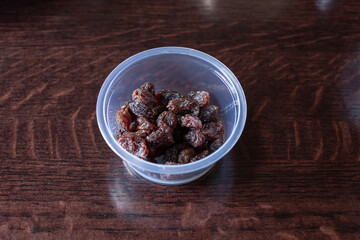A view of a condiment cup of raisins.
