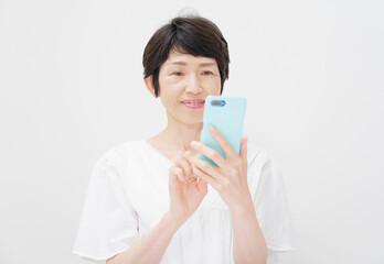 スマホを使う中年女性　白背景