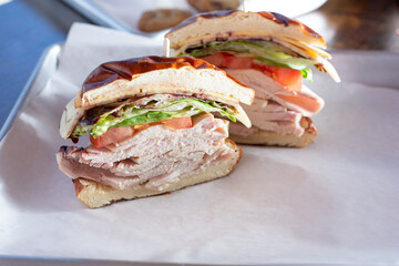 A view of a turkey sandwich, featuring a pretzel bun.