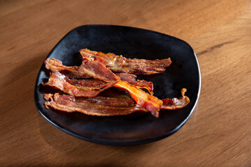 A view of a plate of bacon strips.