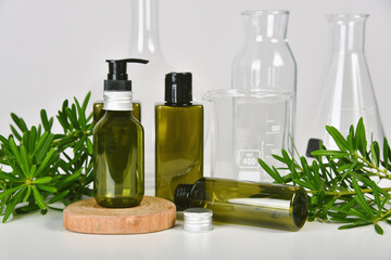 Natural skincare beauty product, Cosmetic green bottle containers packaging with green nature leaves, Organic extraction and scientific lab glassware, Herbal healthy skin care.