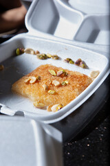 A view of a styrofoam to go container of knafeh dessert.