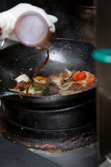 A view of a kitchen wok cooking shaken beef.
