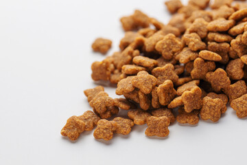 Dry feed pellets for dogs on a white background.