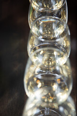 A closeup view of several wine glasses filled with white wine, as a background.