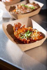 A view of a tray of some garnished glazed chicken wings.