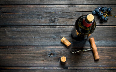 bottle of red wine with grapes.