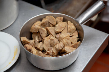 A view of a pot holding an inventory of sliced beef meatballs, used for Vietnamese pho.