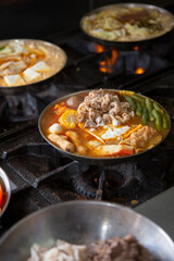 A view of several hot pots cooking on an industrial range, seen at a local restaurant kitchen.