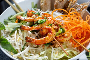 A closeup view of a bowl of Vietnamese shrimp vermicelli, known as bun tom nuong.