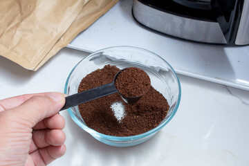 A view of a glass bowl of ground coffee, in a home kitchen lifestyle setting.