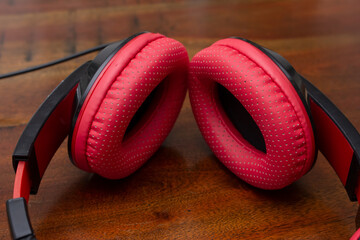 A view of a pair of red headphones on a table surface.