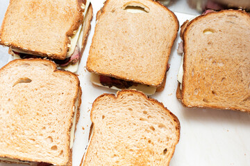A top down view of the preparation of several sandwiches.