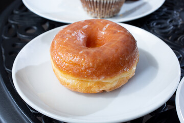 A view of a glazed donut on a plate.