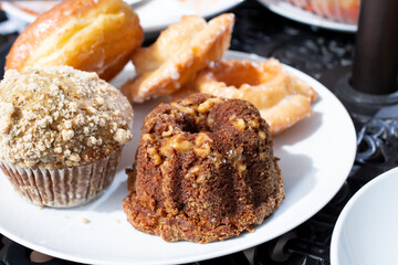 A view of a variety of pastries, featuring bundt cake, cupcake, and donuts.
