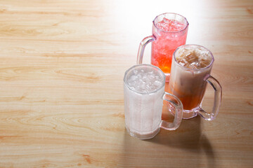 A view of some refreshing beverages in plastic pint mugs, on the right side of the frame.