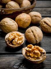 Peeled walnut on wooden background.