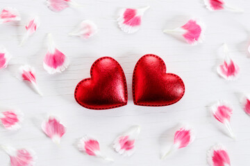 Red hearts and petals on wooden background. Top view.