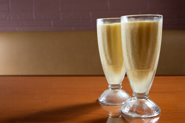 A view of some yellow colored milk shakes on the right side of the frame.