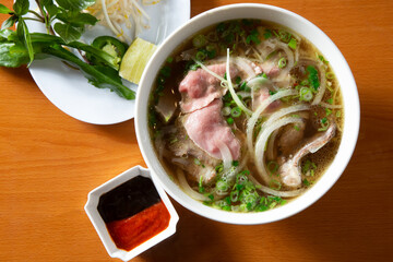 A top down view of a pho combo bowl, among other Vietnamese entrees.