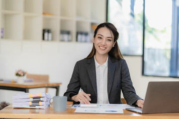 Asian businesswoman working with laptop computer and calculator financial documents on table make a plan analyzing financial reports business plan investment in the office