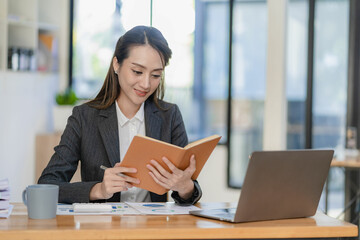 Asian businesswoman working with laptop computer and calculator financial documents on table make a plan analyzing financial reports business plan investment in the office