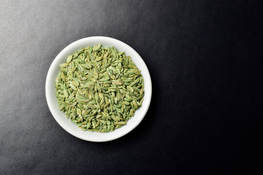 Fennel seeds in bowl on dark background
