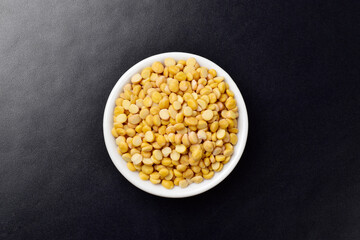 Top view of chana dal in bowl on dark background