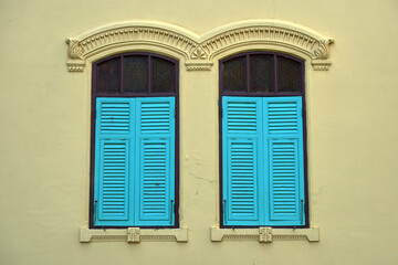 Blue ancient window on a yellow wall