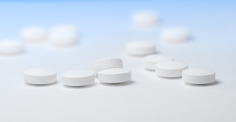Heap of white pills on a white table
