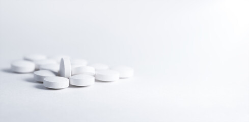 Vitamin, tablets and capsules on bright paper background. Soft focus, close up, copy space.