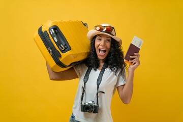 Happy Traveler curly Latin woman wears white t-shirt hold suitcase bag, passport and boarding...