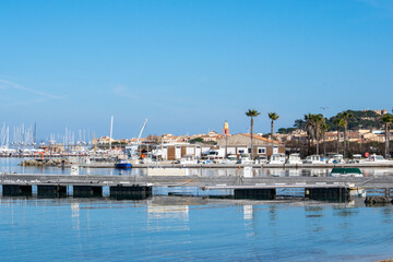 Fototapeta na wymiar Saint Tropez view from far away with palm trees water and blue sky