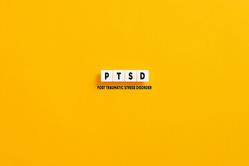 White letter blocks on yellow background with the acronym PTSD post traumatic stress disorder.