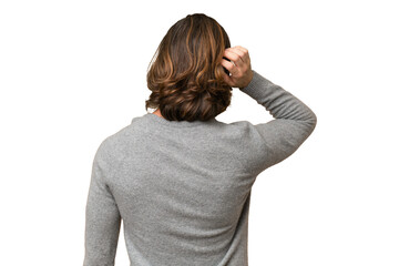 Young caucasian man isolated on green chroma background in back position and thinking