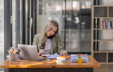 Portrait of tired young business Asian woman work with documents tax laptop computer in office. Pensive, Sad, unhappy, Worried, Depression, or employee life stress concept