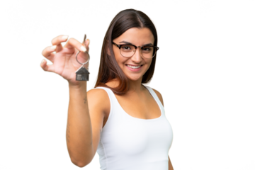 Young caucasian woman holding home keys isolated on green chroma background with happy expression