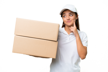 Delivery caucasian woman holding boxes isolated on green chroma background thinking an idea while looking up