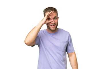 Young handsome caucasian man isolated on green chroma background showing ok sign with fingers