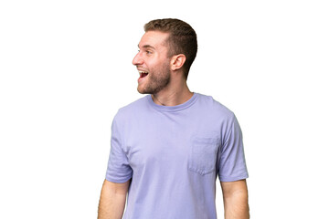 Young handsome caucasian man isolated on green chroma background laughing in lateral position