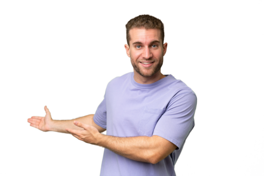 Young handsome caucasian man isolated on green chroma background extending hands to the side for inviting to come