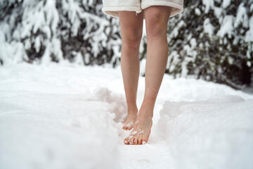 Caucasian woman standing barefoot in snow