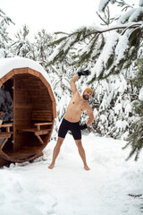 Caucasian man warming up before winter swim in barrel