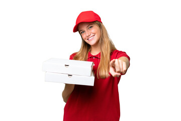 Young caucasian pizza delivery woman with work uniform picking up pizza boxes over isolated background pointing front with happy expression