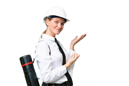 Young architect caucasian woman with helmet and holding blueprints over isolated background extending hands to the side for inviting to come