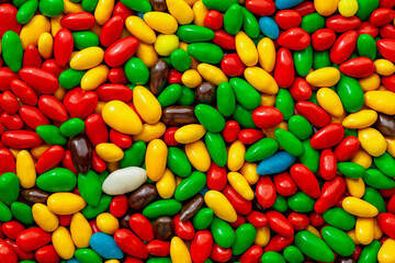 Candy in multi colored glaze close-up, in bulk, mini pieces, wallpaper background