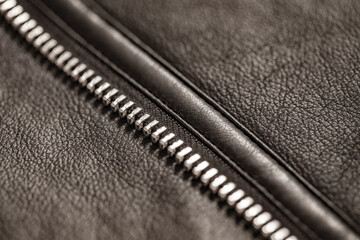 Zipper closure with metal teeth, one of halves, on faux leather jacket close-up, selective focus